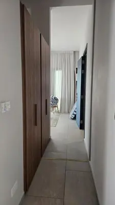 a hallway with two wooden doors and a room at 1BR Serviced Apt with Pool & Premium Amenities in Voroklini