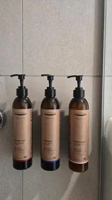 three bottles of soap on a wall in a bathroom at 1BR Serviced Apt with Pool & Premium Amenities in Voroklini