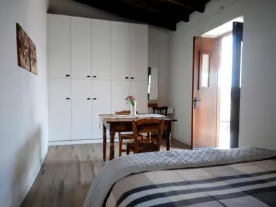 a bedroom with a table and white cabinets and a bed at En chirokitia cottages in Chirokitia