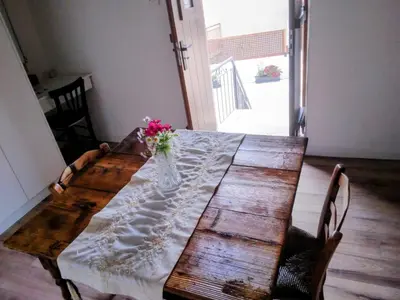 a wooden table with a vase of flowers on it at En chirokitia cottages in Chirokitia