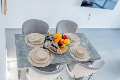 a table with chairs and a bowl of fruit on it at TelMar White House - 100m from the Sea in Voroklini