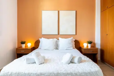 a bedroom with a white bed with three pictures on the wall at Odin 1-BR Apartment & Balcony in Larnaca in Larnaka