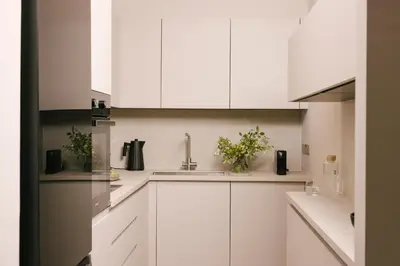 a white kitchen with white cabinets and a sink at Pinewood by Holistays in Engomi
