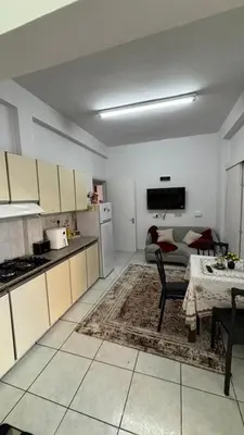 a kitchen and living room with a table and a couch at Coast & City Apartment in Limassol