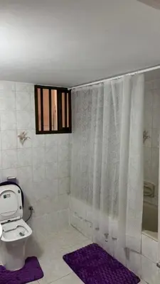 a bathroom with a white toilet and a window at Coast & City Apartment in Limassol