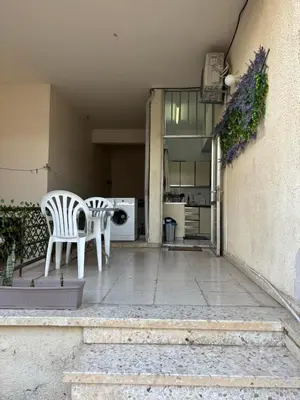a patio with two white chairs and a table at Coast & City Apartment in Limassol