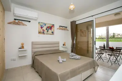 a bedroom with a bed and a balcony at Modern & Fancy ground floor Studio - Pool & Relax in Tersephanou
