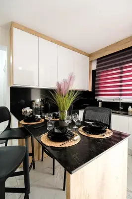 a kitchen with a dining table with black counter tops at Cozy 1BR Apartment with Terrace in Phrenaros