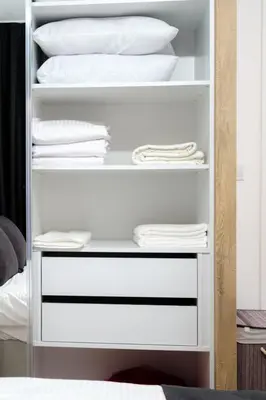a white closet with white pillows and towels at Cozy 1BR Apartment with Terrace in Phrenaros