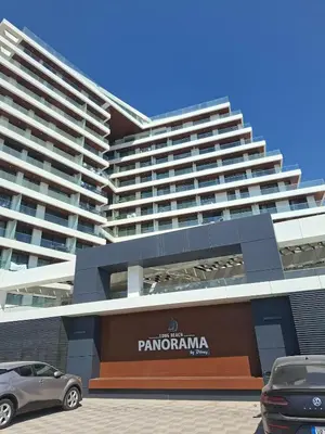 a parking lot in front of a large building at Panorama Comfort Suita in Protaras