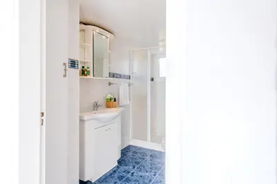 a white bathroom with a sink and a mirror at TelMar Port Sea View - 10 minutes walk from Finikoudes in Larnaka