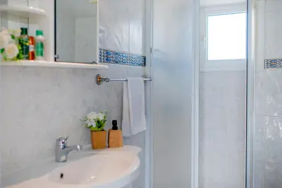 a bathroom with a sink and a shower at TelMar Port Sea View - 10 minutes walk from Finikoudes in Larnaka
