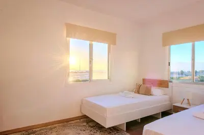 a bedroom with two beds and two windows at TelMar Port Sea View - 10 minutes walk from Finikoudes in Larnaka