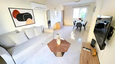 a living room with a couch and a table at 2 Apartments Retreat with Pool & Free Wi-Fi in Larnaka
