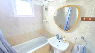 a bathroom with a sink and a tub and a mirror at 2 Apartments Retreat with Pool & Free Wi-Fi in Larnaka