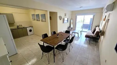a kitchen and dining room with a table and chairs at 2 Apartments Retreat with Pool & Free Wi-Fi in Larnaka