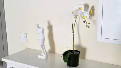 a white statue sitting on a table next to a white flower at 2 Apartments Retreat with Pool & Free Wi-Fi in Larnaka
