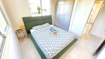 a bedroom with a bed with a purse on it at 2 Apartments Retreat with Pool & Free Wi-Fi in Larnaka