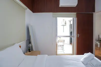 a bedroom with a bed and an open door at Palmove Makenzy Charming 1Bed Apt in Larnaka