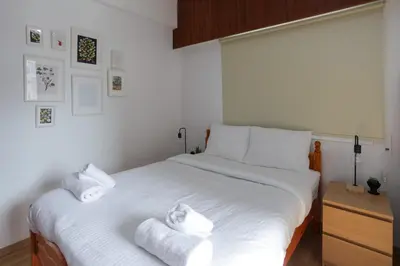 a bedroom with a large white bed with towels on it at Palmove Makenzy Charming 1Bed Apt in Larnaka