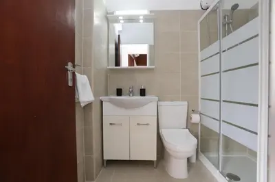 a bathroom with a toilet and a sink and a mirror at Palmove Makenzy Charming 1Bed Apt in Larnaka