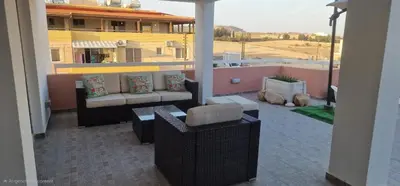 a patio with a couch and a table and a building at 3 Bedroom Penthouse Livadia Larnaca in Livadhia