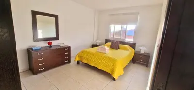 a bedroom with a bed and a dresser and a mirror at 3 Bedroom Penthouse Livadia Larnaca in Livadhia