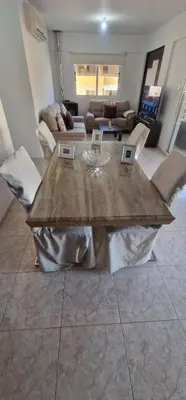 a living room with a table and a couch at 3 Bedroom Penthouse Livadia Larnaca in Livadhia