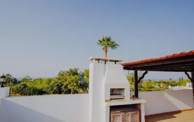 a white building with a palm tree on top of it at Private Bungalow with private pool and parking in Alsancak Kyrenia North Cyprus in Phikardhou