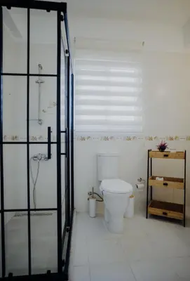 a bathroom with a toilet and a shower and a glass door at Private Bungalow with private pool and parking in Alsancak Kyrenia North Cyprus in Phikardhou