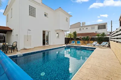 a swimming pool in front of a white house at Villa St George - 3 Bed Villa with Private Pool in Xylophaghou