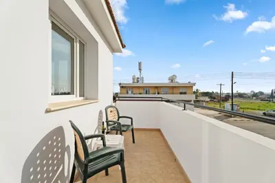 a balcony with chairs and a view of a building at Villa St George - 3 Bed Villa with Private Pool in Xylophaghou