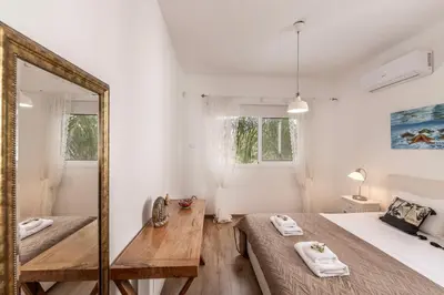 a bedroom with two beds and a mirror at Protaras Seaside Villa Narcissos 2 in Protaras