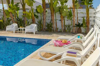 a pool with chaise lounge chairs and a swimming pool at Protaras Villa Alina in Protaras