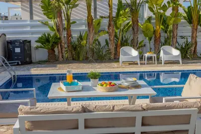 a table with food on it next to a swimming pool at Protaras Villa Alina in Protaras