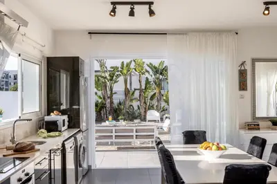 a kitchen with a table and chairs and a view of the ocean at Protaras Villa Alina in Protaras