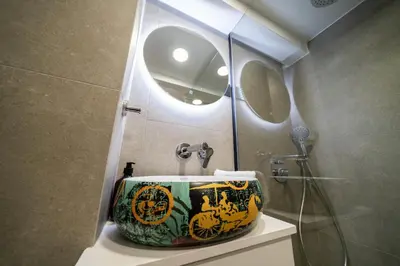 a bathroom with a sink and a shower with a mirror at New luxury studio in the historic center in Limassol