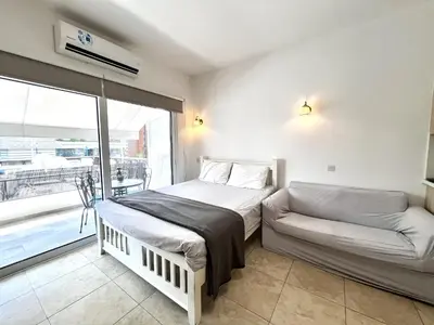 a bedroom with a bed and a couch and a window at STAY Sunsea Studio in Limassol