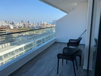 a balcony with two chairs and a view of a city at Grand Sapphire Iskele Apartment С 161 in Larnaka