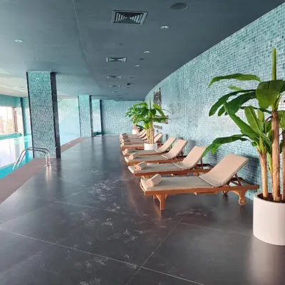 a row of lounge chairs in a room with plants at Grand Sapphire Iskele Apartment С 161 in Larnaka