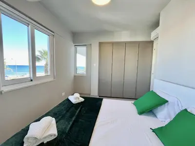 a bedroom with a bed with a view of the beach at STAY Atalanta Apartment in Larnaka