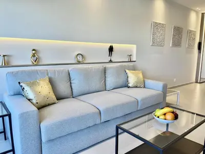 a living room with a blue couch and a glass table at STAY Atalanta Apartment in Larnaka