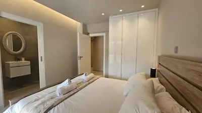 a bedroom with a large white bed with a mirror at STAY Executive Retreat in Nicosia
