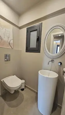 a bathroom with a toilet and a sink and a mirror at STAY Executive Retreat in Nicosia