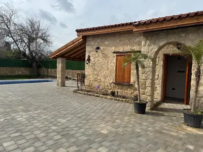a stone house with a patio and a building at Stone house in Pallouriotissa