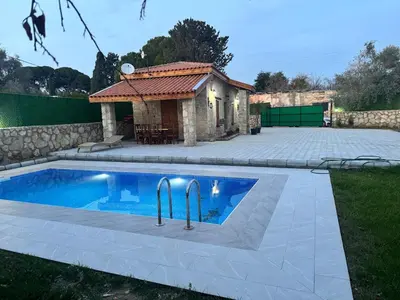 a swimming pool in a yard with a building at Stone house in Pallouriotissa