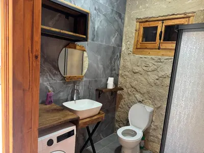 a bathroom with a sink and a toilet and a mirror at Stone house in Pallouriotissa