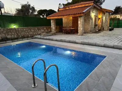 a swimming pool in front of a house at Stone house in Pallouriotissa