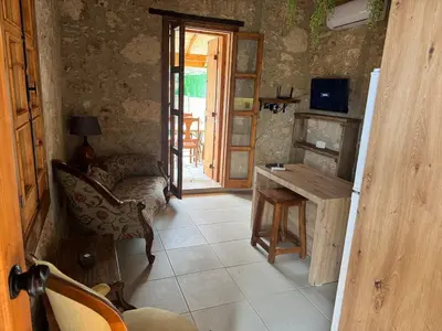 a room with a table and a chair and a desk at Stone house in Pallouriotissa