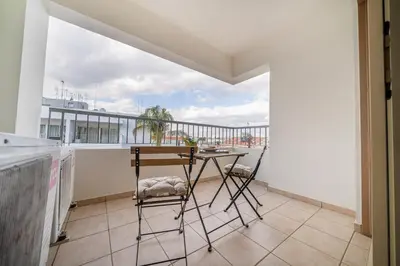 a balcony with a table and chairs on it at 1 bedroom flat in Nicosia